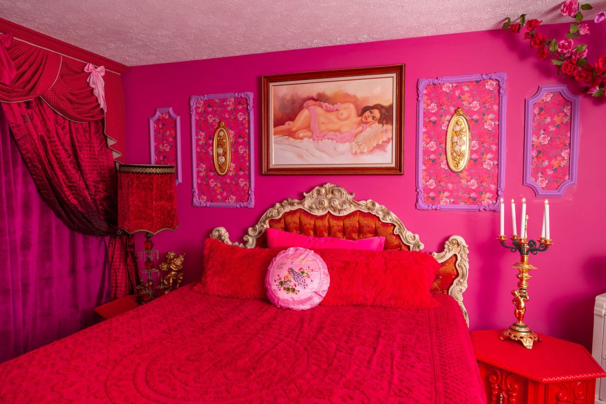 Cupid’s Cottage pink bedroom with ornate bed and floral walls